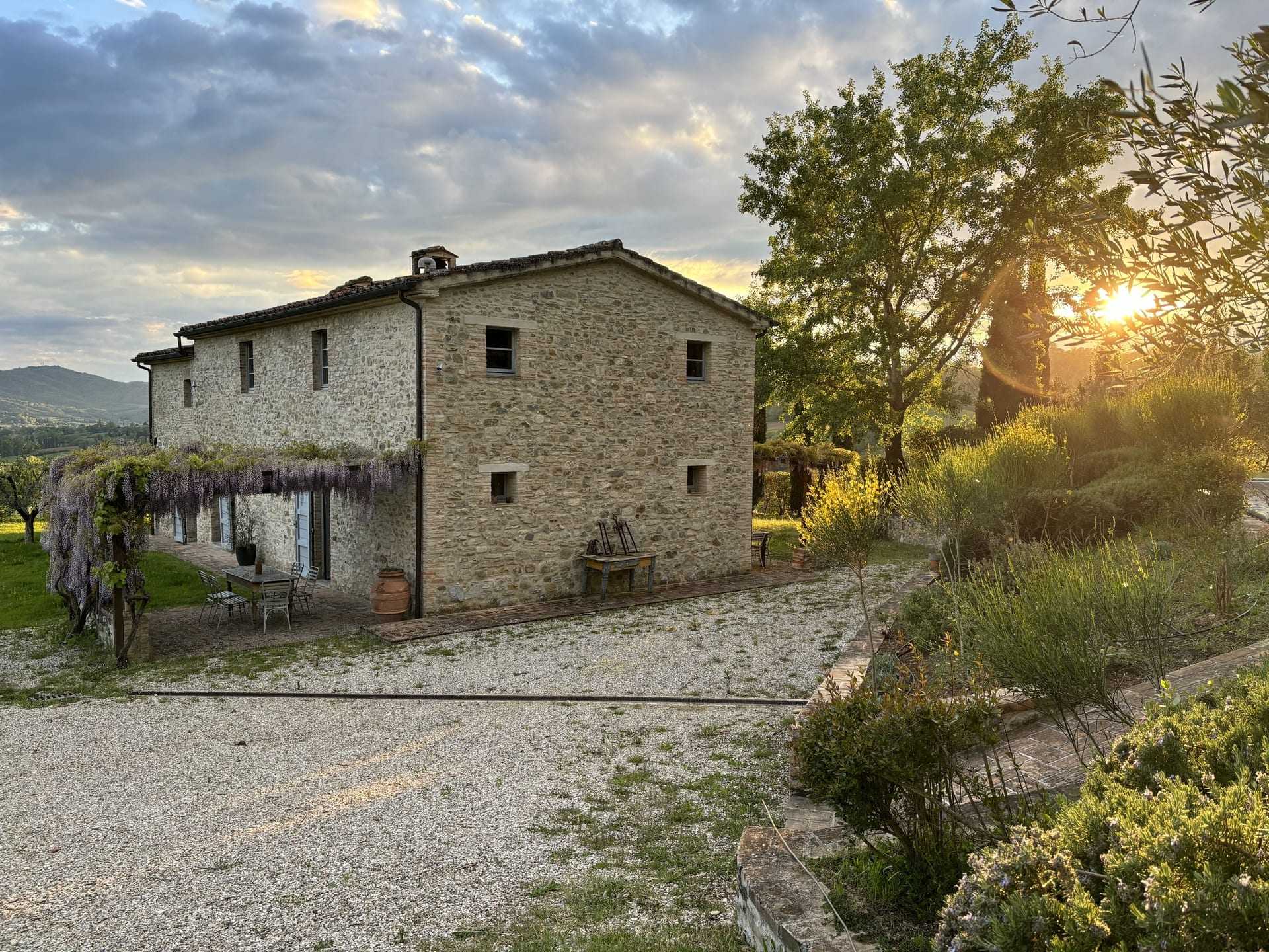 Il casale in pietra all’imbrunire, con la luna sopra gli olivi